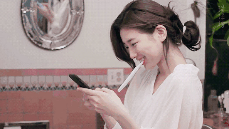 女神在家里刷着牙与女朋友用手机聊天gif图片