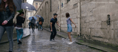 一对情侣在有积水的大街上蹦蹦跳跳gif图片